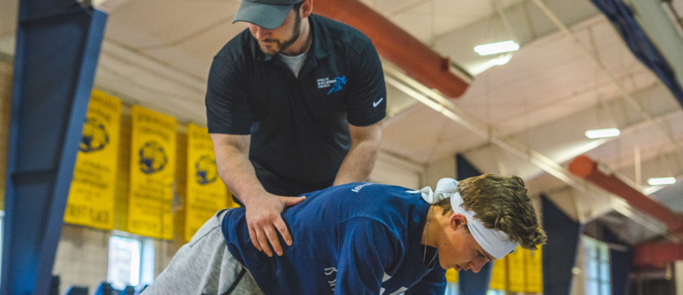 Coach helping man with exercise